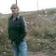 A woman wearing sunglasses takes a shit outside along the railroad tracks - probably somewhere in Europe.